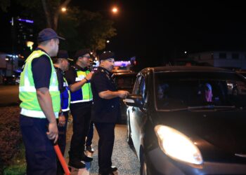 MUHAMMAD Kifli Ma Hassan (kiri) memeriksa kenderaan pada Op bersepadu Khas pada Ambang Tahun Baharu di Kota Bharu, Kelantan, malam tadi. - UTUSAN/KAMARUL BISMI KAMARUZAMAN