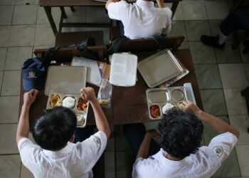 PELAJAR Sekolah Menengah Rendah PGRI 6 Bogor, Jawa Barat menikmati hidangan pada hari pertama program makanan percuma.- AFP