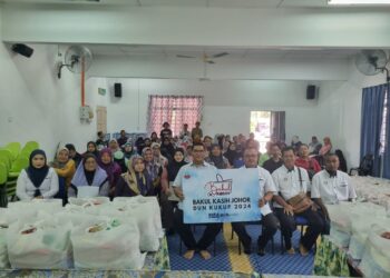 Jefrdin Atan (tengah) bersama penduduk Kampung Sungai Burung, Pekan Nanas dalam program penyampaian Bakul Kasih Johor di Pontian,  Johor, semalam.