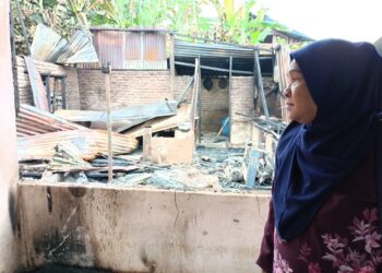NORMADIAH Hassan merenung sayu melihat kesan kebakaran rumahnya yang berlaku di Kampung Charuk Kapas, Kuala Pegang, Baling.