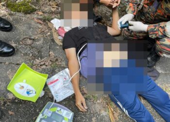 ANGGOTA bomba memberi bantuan kepada seorang lelaki yang mengalami sesak nafas ketika mendaki Bukit Kledang di Ipoh hari ini. - UTUSAN