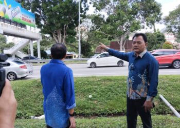 RAHMAD Mariman (dua dari kanan) menunjukkan lokasi kain rentang mempromosikan ajaran The Ahmadi digantung pada jejantas di Peringgit Jaya, Melaka. - UTUSAN/MUHAMMAD SHAHIZAM TAZALI