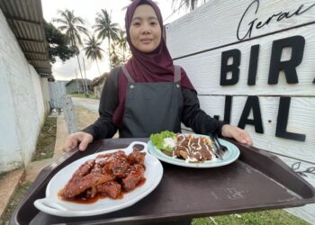KARIMAH Hussin bersama hidangan di Kedai Bira Jale, Kampung Gajah Mati Semerak, 
             Pasir Puteh, Kelantan 
                        baru-baru ini. 
                               – MINGGUAN/TOREK 
                                         SULONG