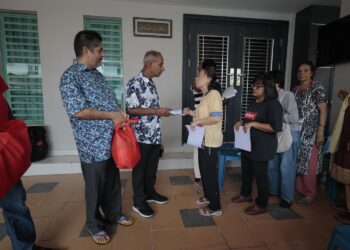 M. KULASEGARAN (dua dari kiri) menyampaikan sumbangan kepada mangsa banjir di kawasan Fair Park di Arena Kepayang Putra, Ipoh hari ini. - UTUSAN