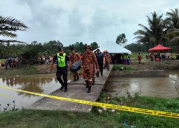 MAYAT Muhammad Asadullah Zehan diusung anggota bomba dan polis selepas ditemukan terjatuh ke dalam tali air di Kampung Kubang Telaga, Bachok, Kelantan. -ROHANA MOHD. NAWI