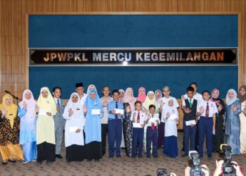 FADHLINA Sidek (tengah) bergambar bersama pelajar dan ibu bapa selepas penyerahan cek bantuan awal persekolahan di Jabatan Pendidikan Wilayah Persekutuan, Kuala Lumpur. - UTUSAN/ISKANDAR ISHAK