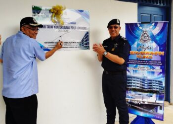 SHAMSUL Anuar Nasarah menandatangani plak sebagai merasmikan kuaters Balai Polis Lenggong hari ini. - UTUSAN/FADZIL ZAINOL