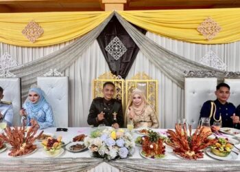 TIGA pasangan pengantin yang melangsungkan majlis perkahwinan serentak di Lambor Kiri di Parit semalam. - UTUSAN/AIN SAFRE BIDIN