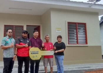 THAM Seng Chong (dua dari kanan) menerima replika kunci rumah barunya daripada Choong Shin Heng (tengah) di Kampung Baru Bukit Pagar, Tapah, Perak. - UTUSAN/MEGAT LUTFI MEGAT RAHIM