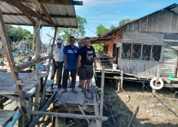 ZAINI Ali (kanan) menunjukkan bahagian jeti yang runtuh di Pangkalan Nelayan Penghulu, Serkat, Pontian.