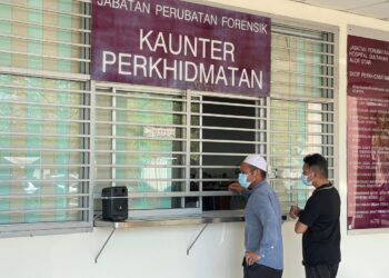 MOHD. Nazir Saad (kiri) menguruskan pengecaman mayat di pekarangan Jabatan Forensik Hospital Sultanah Bahiyah (HSB) Alor Setar Kedah hari ini.