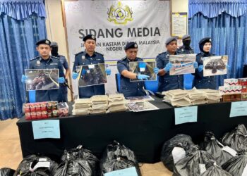 ISMAIL Hashim (tiga dari kiri) menunjukkan bungkusan plastik hitam yang dirampas dipercayai mengandungi daun ketum menerusi pemeriksaan ke atas dua bot fiber di perairan Sungai Padang, Simpang Empat, Perlis. - UTUSAN/ASYRAF MUHAMMAD