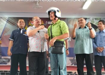 AEDY Fadly Ramli (kiri) bersama Shamsul Iskandar Mohd. Akin (dua kiri) menyampaikan topi keledar kepada seorang penerima di SK Bendang Nyior, Tanah Merah, Kelantan-UTUSAN/ROHANA ISMAIL.