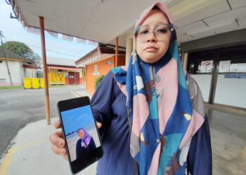 SITI Nurul Fatihah Mahmud menunjukkan gambar Allahyarham Siti Nabila yang maut dalam kemalangan di Kilometer 52 Jalan Johor Bahru-Mersing, petang semalam.
