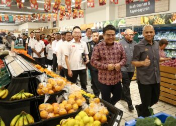 WOO Kah Leong (kiri) mengiringi Menteri KPDN, Datuk Armizan Mohd. Ali (kanan) meninjau harga barang pada Jualan Rahmah Madani dan Pengumuman SHMMP Tahun Baharu Cina di Teluk Intan hari ini. - UTUSAN/MUHAMAD NAZREEN SYAH MUSTHAFA