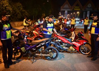 MOHD. Zamri Samion (tengah) menunjukkan motosikal yang disita kerana didapati diubah suai secara ekstrem menerusi Op Khas Motosikal 2024 di Jambatan Sultan Mahmud, Kuala Terengganu, malam tadi. - UTUSAN/PUQTRA HAIRRY