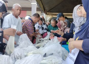 ORANG ramai mengambil ikan yang diedarkan secara percuma di Bukit Gantang hari ini. - UTUSAN/WAT KAMAL ABAS