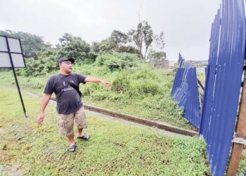MD. AZLAN Mustapar menunjukkan kawasan longkang yang didakwa tersumbat sehingga menyebabkan banjir Taman Mawai dan Taman Aman, Kota Tinggi, Johor.