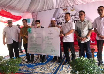 NIK Nazmi Nik Ahmad (tiga dari kanan) menyerahkan Mock Title kepada wakil pendududk sambil diperhatikan Menteri Besar Kelantan, Datuk  Mohd. Nassuruddin Daud (tengah) di Kota Bharu, Kelantan. - UTUSAN/ROSLIZA MOHAMED
