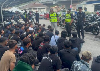 SAZALEE Adam (berdiri, tiga dari kanan) memberi nasihat kepada para penunggang motosikal yang ditahan dalam O Samseng Jalanan di Jambatan Kedua Pulau Pinang.