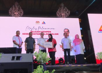 FAHMI Fadzil (tiga dari kiri) menyampaikan komputer riba kepada mahasiswa Universiti Malaysia Kelantan (UMK) yang terjejas banjir di Majlis Pelancaran Jelajah Kempen Keselamatan di UMK, Pengkalan Chepa Kota Bharu, Kelantan. - UTUSAN/ROSLIZA MOHAMED