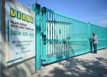 MARZUKHI Othman sayu mengunci pintu pagar kilang padi miliknya yang merupakan kilang padi bumiputera terbesar di negara ini apabila sudah tidak mampu lagi bertahan di Dibuk Sdn. Bhd, Kilometer 7, Jalan Simpang Empat, Kangar, Perlis baru-baru ini.-UTUSAN/IZLIZAN OTHMAN