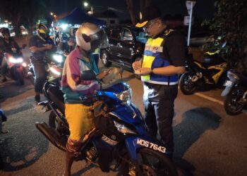 MUHAMMAD FIRDAUS Shariff memeriksa lesen seorang penunggang motosikal dalam Operasi Khas Tahun Baharu Cina 2025 di Lebuh AMJ berhampiran Terminal Melaka Sentral, Melaka. - UTUSAN/AMRAN MULUP