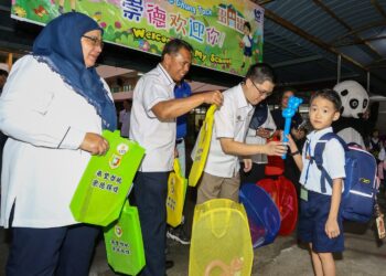 WONG Kah Woh menyantuni murid pada hari pertama persekolahan di Sekolah Jenis Kebangsaan Cina (SJKC) Chung Tack, Ipoh, Perak, semalam. – UTUSAN/MUHAMAD NAZREEN SYAH MUSTHAFA