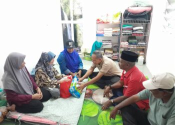 RAZAK Daud (tiga dari kanan) menyumbangkan barang keperluan dapur kepada seorang warga emas ketika program Ziarah Kasih di Kampung Sungai Kepong, Pulau Tawar di Jerantut, Pahang. - UTUSAN/HARIS FADILAH AHMAD
