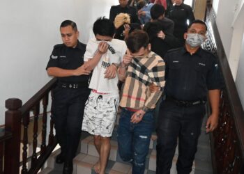 KESEMUA tertuduh diiringi anggota polis ketika dihadapkan ke Mahkamah Majistret Ayer Keroh, Melaka. PIX/ MUHAMMAD SHAHIZAM TAZALI