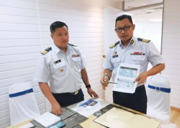 MOHAMAD Shukri Khotob (kanan) dan Timbalan Pengarah Operasi Maritim Negeri Perak, Komander Maritim Tan Ah Bik menunjukkan peta sempadan perairan Malaysia dan Indonesia ketika ditemui di Lumut, Perak semalam. – UTUSAN/AIN SAFRE BIDIN