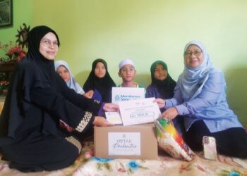 SUHARA Mustaffa (kanan) menyampaikan Faedah Pengurusan Mayat Perkeso berjumlah RM3,000  kepada waris Nasrul Hadi Saiadin di Kampung Raja, Besut, Terengganu. – UTUSAN/WAN ZURATIKAH IFFAH WAN ZULKIFLI