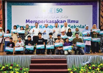 MUHAMMAD Khawarizmi Muhammad Harris (depan, lima dari kiri) bersama sebahagian murid yang menerima bantuan dalam Majlis Sumbangan Petronas menerusi program Kembali 
Ke Sekolah 2025 di Kuala Terengganu, Terengganu semalam.