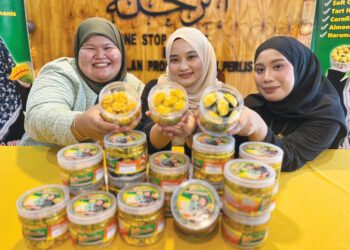 ATHIFAH Najwani Shahidan (tengah) menunjukkan antara kuih raya berasaskan harumanis  di Pusat Agro Pelancongan Bukit Temiang, Padang Besar, Perlis, semalam. – UTUSAN/ASYRAF MUHAMMAD