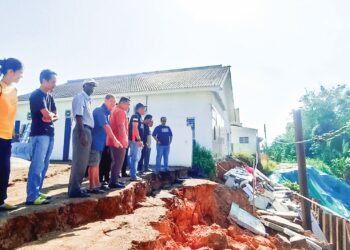 Penduduk melihat keadaan tanah runtuh yang berlaku berdekatan rumah penduduk di Taman Bunga Raya di Tapah, Perak  semalam. – UTUSAN/ MEGAT LUTFI MEGAT RAHIM