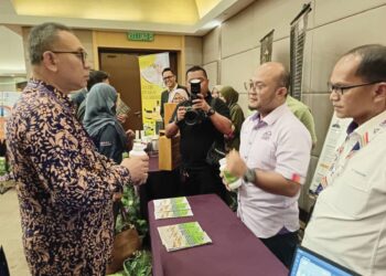 MOHD. Zamri Ibrahim (kiri) mendengar penerangan mengenai produk penyelidikan yang dikomersialkan oleh Universiti Malaysia Terengganu (UMT) dalam Majlis Apresiasi di Kuala Terengganu, semalam. – UTUSAN/KAMALIZA KAMARUDDIN