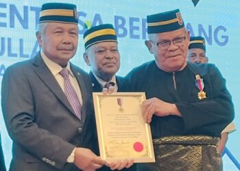 SHARUDDIN OMAR (kiri) menyampaikan Pingat Setia Sentiasa Berjuang (PSSB) kepada Ahli Persatuan Veteran Angkatan Tentera Malaysia (PVATM) Cawangan Kluang bersempena Mesyuarat Agung PVATM Cawangan Kluang di Kluang semalam.