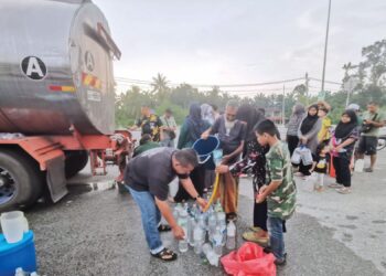 PENDUDUK mengambil air dari lori tangki di Kampung Bahagia di Teluk Intan, Perak semalam. – UTUSAN/AIN SAFRE BIDIN