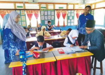 ZAITON Hashim dan Ismail Daud (kanan) bersama murid pada hari pertama sesi persekolahan 2024/2025 di SK Tebing Rebak, Bagan Datuk, Perak kelmarin. – UTUSAN/AIN SAFRE BIDIN