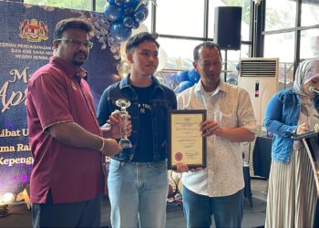 S. VEERAPAN (kiri) menyampaikan Anugerah Khas Tokoh Kepenggunaan Peringkat Negeri Sembilan 2024 kepada Muhammad Fareez Hafizie (tengah) pada Majlis Apresasi dan Sesi Libat Urus KPDN Negeri Sembilan bersama Rakan Strategik Kepenggunaan 2024 di Nilai, Seremban hari ini. - UTUSAN /NUR SHARIEZA ISMAIL