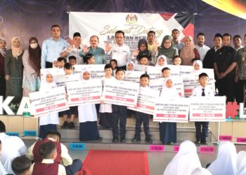 Ruji Ubi menyampaikan bantuan awal persekolahan RM150 kepada murid tahun 1 sempena Lawatan Kerja pada hari pertama pembukaan persekolahan Kalendar Akademik Sesi 2025/2026 di SK Jalan Datuk Palembang, Bukit Baru, Melaka. UTUSAN/AMRAN MULUP