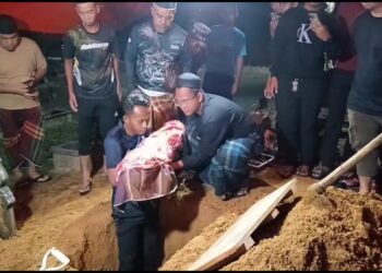 JENAZAH Hud Aryan Mohd. Nur Hafifi dibawa masuk ke liang lahad untuk dikebumikan di Tanah Perkuburan Islam Kampung Kuala Tiga, Tanah Merah, Kelantan, semalam. – UTUSAN/ROHANA MOHD. NAWI