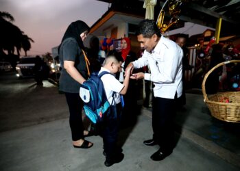 MAT Lazim Mohammad (kanan) menyantuni murid tahun satu semasa turun padang ke Sekolah Kebangsaan Ismail 1, Kota Bharu, Kelantan, semalam. – UTUSAN/KAMARUL BISMI KAMARUZAMAN