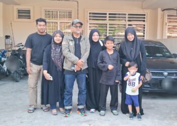 AHMAD NOR Al Faizan Jusoh (tiga dari kiri) bergambar bersama anak dan menantunya sebelum bertolak ke ibu negara ketika ditemui di kediamannya di Kampung Mak Chili, Kemaman, Terengganu.