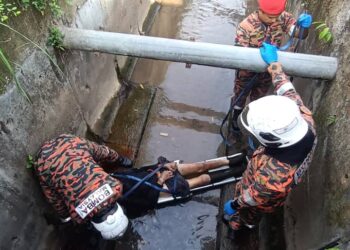 ANGGOTA bomba mengangkat mayat lelaki yang ditemukan dalam longkang di Kawasan Perindustrian Silibin, Ipoh hari ini. - UTUSAN/IHSAN JBPM