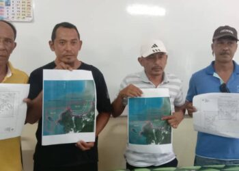 MOHD. Faizal Mat Zin (dua dari kiri) dan Faizul Sofian (dua dari kanan) bersama dua nelayan lain menunjukkan peta lokasi yang akan dilombong pada sidang akhbar di Pantai Remis, Perak, hari ini. - UTUSAN