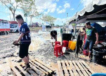 PARA peniaga membersihkan barangan dan berkemas selepas tidak meneruskan operasi perniagaan selepas tapak Pesta Angin Timur 2025 digenangi air dan selut tebal berikutan hujan di Kampung Lat Seribu, Tambun Tulang, Perlis baru-baru ini.- UTUSAN/ASYRAF MUHAMMAD