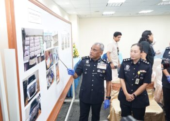RAMLI Mohamed Yoosuf menunjukkan barang rampasan sindiket pusat panggilan penipuan antarabangsa di Jabatan Siasatan Komersial Bukit Aman, Jalan Tun Razak, Kuala Lumpur, semalam.