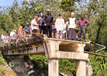 KAKITANGAN Jabatan Pengairan dan Saliran (JPS) Kelantan bersama penduduk kampung meninjau keadaan jambatan yang runtuh akibat banjir di Kampung Rong Chenok, Pasir Mas, Kelantan.
