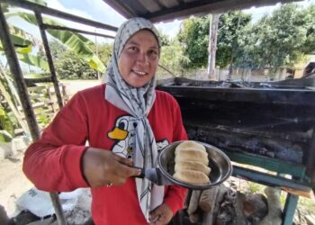 ZALEHA Salim menunjukkan roti yang baharu dibakar dalam ketuhar aluminium yang diciptanya di Kampung Darang Buaya, Besut, Terengganu – UTUSAN/WAN ZURATIKAH IFFAH WAN ZULKIFLI